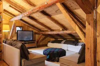 a living room with a couch and a tv at Peter Pan Chalet Luxe Sauna Jacuzzi Cinema Vue 180 in Les Houches