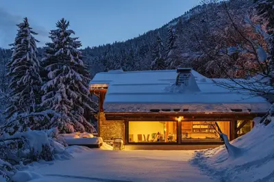 a log cabin in the snow in the woods at Peter Pan Chalet Luxe Sauna Jacuzzi Cinema Vue 180 in Les Houches