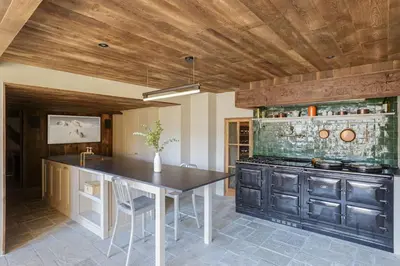 a kitchen with a table and a sink and a stove at Peter Pan Chalet Luxe Sauna Jacuzzi Cinema Vue 180 in Les Houches