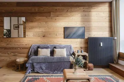 a living room with a blue couch and wooden walls at Vallee Blanche Central 4pax Vue MtBlanc Parking 400m Remontee in Chamonix-Mont-Blanc
