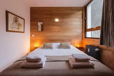 a bedroom with a large bed with two pillows on it at Vallee Blanche Central 4pax Vue MtBlanc Parking 400m Remontee in Chamonix-Mont-Blanc