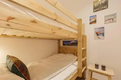 a bedroom with two bunk beds and a tv at Vallee Blanche Central 4pax Vue MtBlanc Parking 400m Remontee in Chamonix-Mont-Blanc