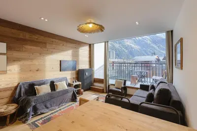 a living room with couches and a large window at Vallee Blanche Central 4pax Vue MtBlanc Parking 400m Remontee in Chamonix-Mont-Blanc