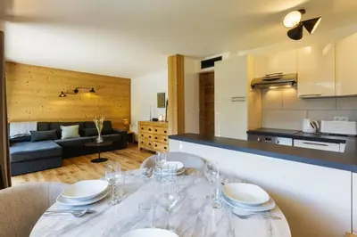a kitchen and living room with a table and chairs at Closy Modern 4pax Pied Piste Centre Balcon Parking in Chamonix-Mont-Blanc