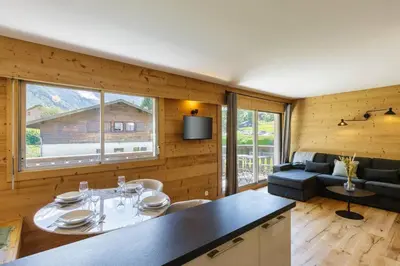 a kitchen and living room with a table and a couch at Closy Modern 4pax Pied Piste Centre Balcon Parking in Chamonix-Mont-Blanc