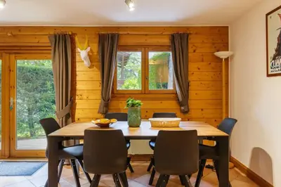 a dining room with a wooden table and chairs at Chavants Apart 3CH Famille Pied Piste Piscine Parking in Les Houches
