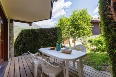 a white table and chairs on a wooden deck at Chavants Apart 3CH Famille Pied Piste Piscine Parking in Les Houches