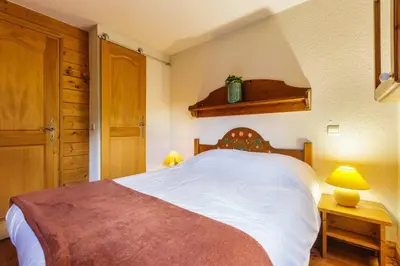 a bedroom with a large white bed and two lamps at Chavants Apart 3CH Famille Pied Piste Piscine Parking in Les Houches