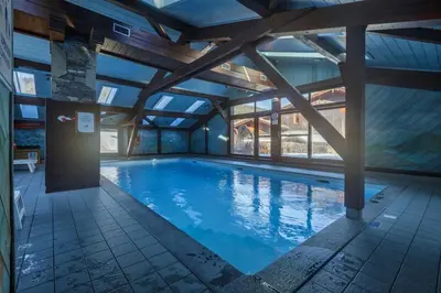 a large swimming pool with a large ceiling at Chavants Apart 3CH Famille Pied Piste Piscine Parking in Les Houches