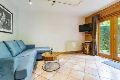 a living room with a blue couch and a table at Chavants Apart 3CH Famille Pied Piste Piscine Parking in Les Houches