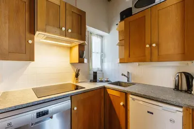 a kitchen with wooden cabinets and a sink and a dishwasher at Moulin - Ultra Central T2 - Vue Mt Blanc - Quartier Vivant in Chamonix-Mont-Blanc