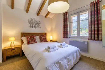 a bedroom with a large bed with towels on it at Moulin - Ultra Central T2 - Vue Mt Blanc - Quartier Vivant in Chamonix-Mont-Blanc