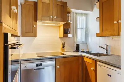 a kitchen with wooden cabinets and a sink at Moulin - Ultra Central T2 - Vue Mt Blanc - Quartier Vivant in Chamonix-Mont-Blanc
