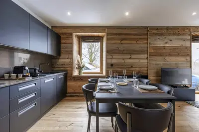a kitchen with a table and chairs in a kitchen at Ocma 4 Somptueux 6pax Central Parking Confort in Chamonix-Mont-Blanc
