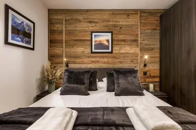 a bedroom with a large bed with a wooden wall at Ocma 4 Somptueux 6pax Central Parking Confort in Chamonix-Mont-Blanc