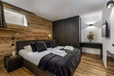 a bedroom with a large bed with wooden walls at Ocma1 Somptueux 6pax Central Parking Confort in Chamonix-Mont-Blanc