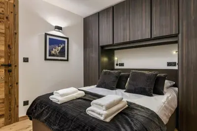 a bedroom with a large bed with towels on it at Ocma1 Somptueux 6pax Central Parking Confort in Chamonix-Mont-Blanc