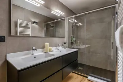 a bathroom with a sink and a glass shower at Ocma1 Somptueux 6pax Central Parking Confort in Chamonix-Mont-Blanc