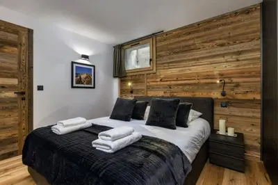 a bedroom with a large bed with wooden walls at Ocma1 Somptueux 6pax Central Parking Confort in Chamonix-Mont-Blanc