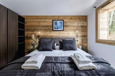a bedroom with a large bed with a wooden wall at Ocma3 Somptueux 6pax VueMtBlanc Central Parking in Chamonix-Mont-Blanc