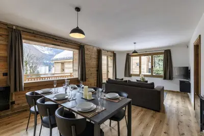 a dining room with a table and chairs and a couch at Ocma2 Somptueux 6pax VueMtBlanc Central Parking in Chamonix-Mont-Blanc
