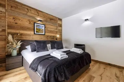 a bedroom with a large bed with wooden walls at Ocma2 Somptueux 6pax VueMtBlanc Central Parking in Chamonix-Mont-Blanc