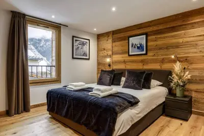 a bedroom with a large bed with wooden walls at Ocma5 Somptueux 6pax Vue MtBlanc Central Parking in Chamonix-Mont-Blanc