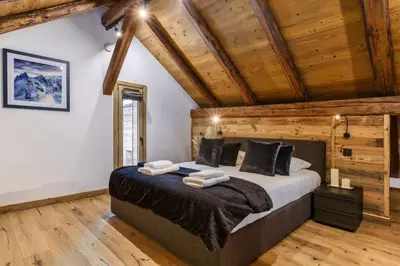 a bedroom with a large bed in a room with wooden ceilings at Ocma5 Somptueux 6pax Vue MtBlanc Central Parking in Chamonix-Mont-Blanc
