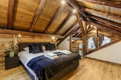 a bedroom with a bed in a room with wooden ceilings at Ocma5 Somptueux 6pax Vue MtBlanc Central Parking in Chamonix-Mont-Blanc