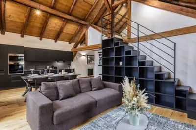 a living room with a couch and a staircase at Ocma5 Somptueux 6pax Vue MtBlanc Central Parking in Chamonix-Mont-Blanc