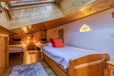 a bedroom with two beds in a wooden cabin at Verny Appart 2CH Familiale Pied Pistes Piscine Vue in Les Houches