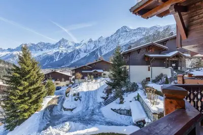 a snow covered resort with mountains in the background at Verny Appart 2CH Familiale Pied Pistes Piscine Vue in Les Houches