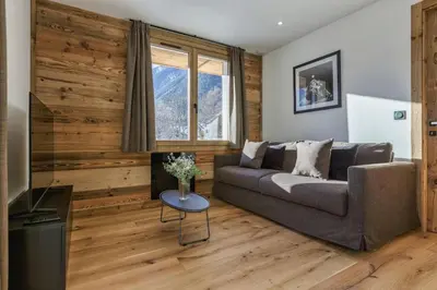 a living room with a couch and a television at Jacaranda2 Sublime 6pax Vue MtBlanc Central Parking in Chamonix-Mont-Blanc