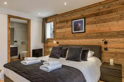 a bedroom with a large bed with wooden walls at Jacaranda1 Sublime 8pax 100m2 Vue MtBlanc Central Parking in Chamonix-Mont-Blanc