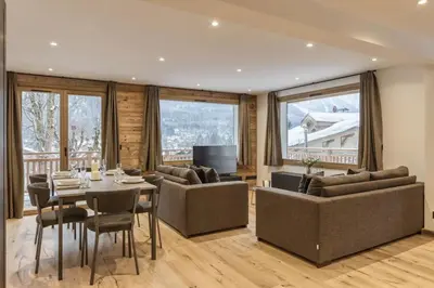 a living room with couches and a table and chairs at Jacaranda1 Sublime 8pax 100m2 Vue MtBlanc Central Parking in Chamonix-Mont-Blanc