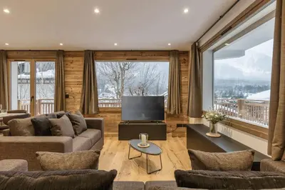 a living room with a couch and a large window at Jacaranda1 Sublime 8pax 100m2 Vue MtBlanc Central Parking in Chamonix-Mont-Blanc