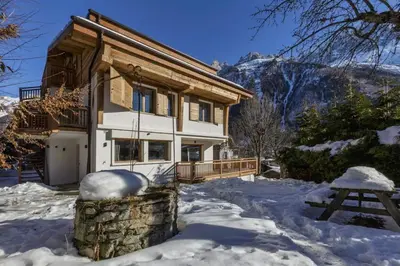 a house in the snow with a picnic table at Jacaranda3 Sublime 6pax Vue MtBlanc Central Parking in Chamonix-Mont-Blanc