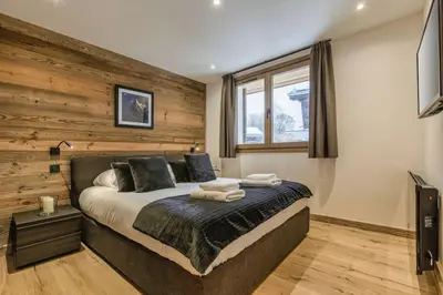 a bedroom with a bed with a wooden wall at Jacaranda3 Sublime 6pax Vue MtBlanc Central Parking in Chamonix-Mont-Blanc