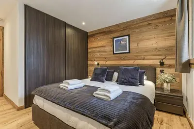 a bedroom with a large bed with towels on it at Jacaranda3 Sublime 6pax Vue MtBlanc Central Parking in Chamonix-Mont-Blanc