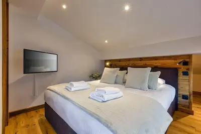 a bedroom with a large bed with towels on it at Jacaranda4 Sublime 6pax 80m2 Vue MtBlanc Central Parking in Chamonix-Mont-Blanc