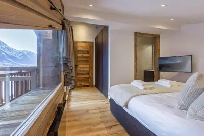 a bedroom with a bed and a large window at Jacaranda4 Sublime 6pax 80m2 Vue MtBlanc Central Parking in Chamonix-Mont-Blanc