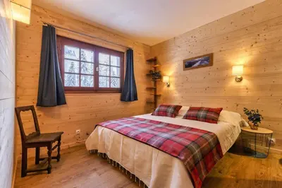 a bedroom with a bed and a chair and a window at La Loriaz Chalet 7pax Nature Le Planet 5mn Argentiere in Chamonix-Mont-Blanc