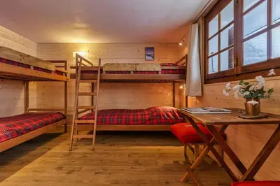 a room with bunk beds and a desk and a table at La Loriaz Chalet 7pax Nature Le Planet 5mn Argentiere in Chamonix-Mont-Blanc