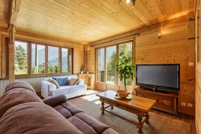a living room with a couch and a flat screen tv at Passy Appart 7pax Vue Vallee Monts Balcon Lumineux in Passy