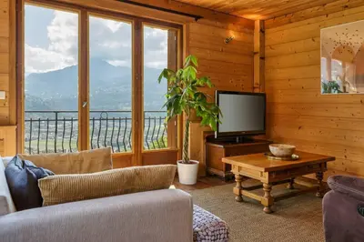 a living room with a tv and a couch and a table at Passy Appart 7pax Vue Vallee Monts Balcon Lumineux in Passy