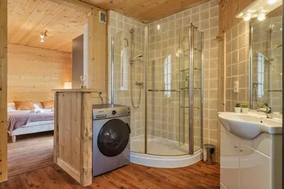 a bathroom with a shower and a sink and a washing machine at Passy Appart 7pax Vue Vallee Monts Balcon Lumineux in Passy