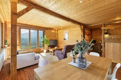 a living room with a wooden ceiling and a table at Passy Appart 7pax Vue Vallee Monts Balcon Lumineux in Passy