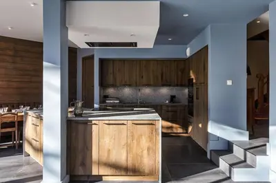 a kitchen with wooden cabinets and a kitchen island at Le Murger Chalet de Luxe 240m2 6 CH Vue MtBlanc Sauna in Chamonix-Mont-Blanc