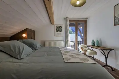 a bedroom with a large bed and a window at Le Murger Chalet de Luxe 240m2 6 CH Vue MtBlanc Sauna in Chamonix-Mont-Blanc