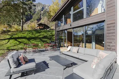 a patio with two couches and a table at Le Murger Chalet de Luxe 240m2 6 CH Vue MtBlanc Sauna in Chamonix-Mont-Blanc